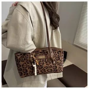 Detalle del bolso tote con estampado de leopardo, colgante de cuentas y etiqueta moda