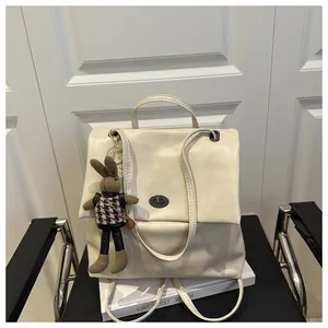 Detail of cream faux leather tote with dark metal turn-lock and knit rabbit charm