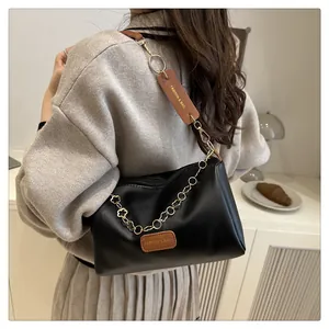 Sac bandoulière tendance en cuir noir avec chaîne et coussinet d'épaule en cuir marron