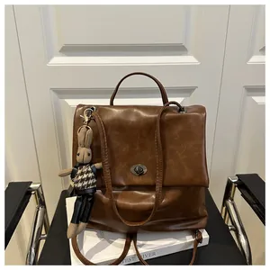 Detail of vintage brown leather backpack with metal turn-lock and cute rabbit pendant