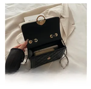 Vue intérieure du sac matelassé noir montrant la capacité pour téléphone et portefeuille