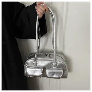 Detail view of metallic silver shoulder bag with double pockets and dual zipper closure