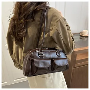 Detailed view of deep brown glossy underarm bag with double pockets and twin straps