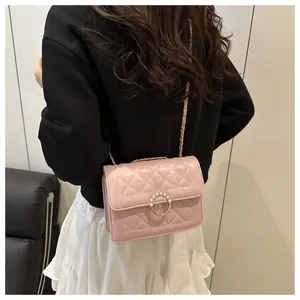 Détail du sac bandoulière rose matelassé avec fermoir anneau doré perlé et bandoulière chaîne