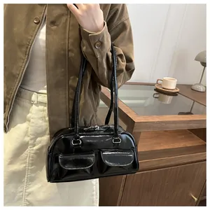 Close-up of black glossy shoulder bag with double front flap pockets and twin zippers