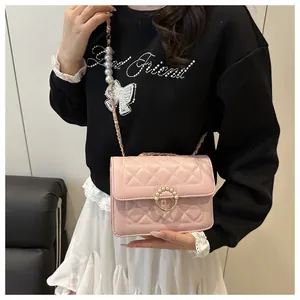 Détail du sac bandoulière matelassé rose avec boucle perle et bandoulière chaîne