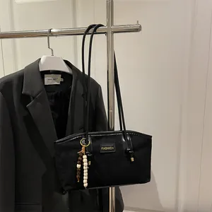 Bolso tote vintage de ante negro con placa dorada de moda y adorno de borla con perlas