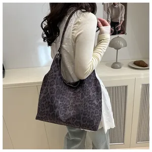 Vue latérale du grand sac cabas léopard porté avec un jean et un haut en dentelle