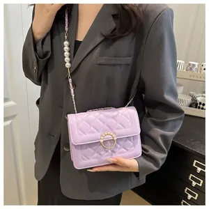 Détail du sac bandoulière matelassé violet avec boucle perle dorée et bandoulière chaîne