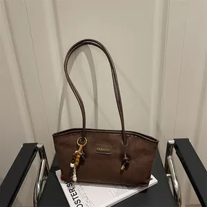 Bolso tote retro de ante marrón con colgante étnico y logotipo de moda en silla