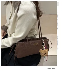 Detail of leopard embossed faux leather texture with a cute brown plush bear charm