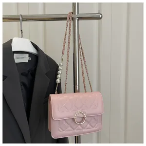 Détail du sac à bandoulière matelassé rose avec chaîne en perles et fermoir anneau