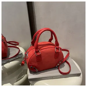 Dettaglio mini borsa bowling rossa in pelle scamosciata con borchie argentate