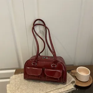 Minimalist burgundy patent leather shoulder bag with two front pockets and silver hardware