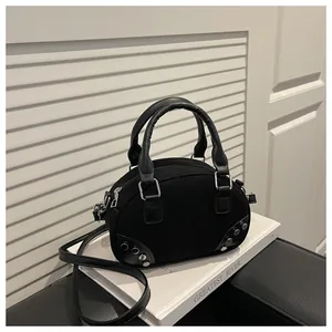 Vista macro della borsa bowling in camoscio nero con borchie argentate e dettagli metallici