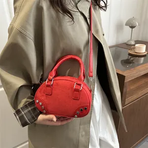 Elegante borsa a mezzaluna in camoscio rosso con borchie argentate su una modella