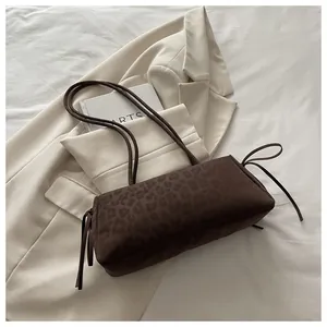 Close-up of vintage brown leopard print shoulder bag on an ivory blazer background