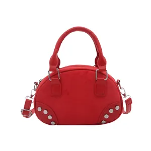 Elegante borsa bowling in camoscio rosso con borchie argentate e tracolla regolabile in studio
