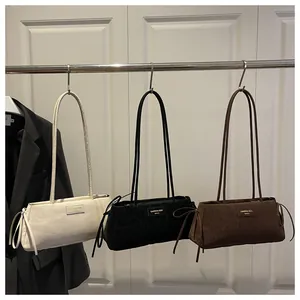 Three baguette shoulder bags in white and leopard print hanging on a metal rack