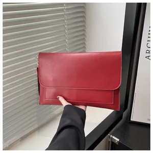 Dettaglio della pochette a busta in pelle rossa con doppia cucitura e fibbia d'argento