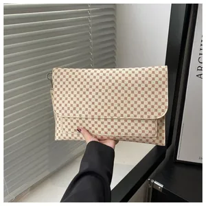 Dettaglio della borsa a bustina beige con motivo rosso e trama in pelle sintetica PU