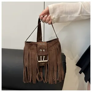 Détail du sac bandoulière en daim marron avec boucle de ceinture et franges bohèmes