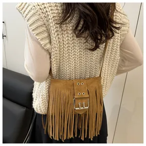 Details van een bruine suède crossbodytas met franjes getoond op een model