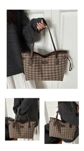 Détail du sac cabas en laine à carreaux avec lanières en cuir et cordons décoratifs