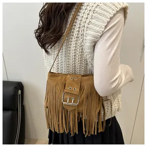 Sac fourre-tout en daim bohème avec franges et boucles porté par un mannequin femme