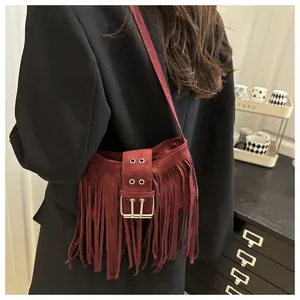 Détail du sac à bandoulière en daim bordeaux avec franges et boucles doubles argentées