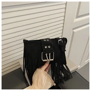 Détail du sac bandoulière en daim noir avec franges longues et boucle métallique