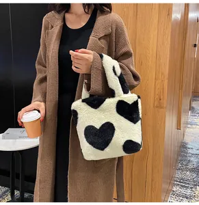 Detail of soft plush bucket bag with heart pattern and cozy faux fur texture