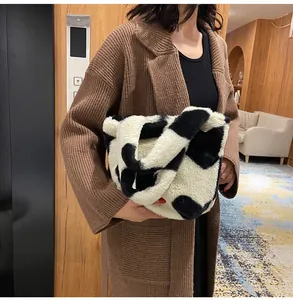 Close-up of plush bucket bag with black and white cow print texture for winter style