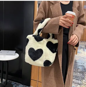 Detail of soft plush bucket bag with black heart patterns and fuzzy texture for winter