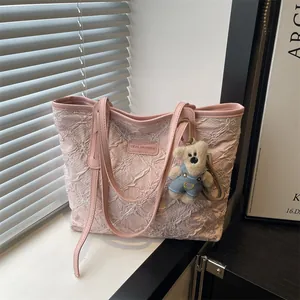 Bolso tote rosa con bordado floral y un pequeño colgante de oso decorativo