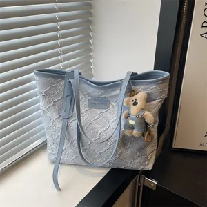 Bolso tote azul claro con bordado floral y colgante de oso con asas de hombro finas