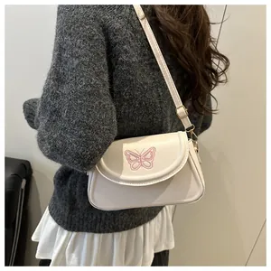 White shoulder bag featuring delicate pink butterfly embroidery and sleek PU leather finish