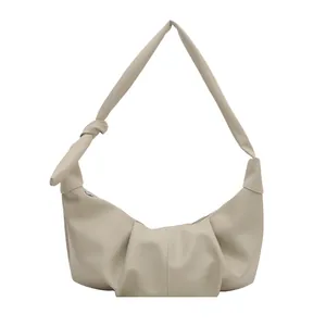 Chic cream dumpling shoulder bag in pebbled leather with pleated design and knot detail