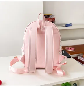 Vue détaillée des bretelles en cuir PU rose et des imprimés cartoon sur le côté du sac