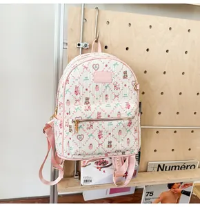 Détail de l'imprimé ours sur sac à dos en toile beige avec bordure rose et zip doré