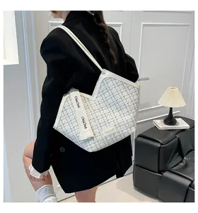 Detailansicht der gewebten Tweed-Tasche mit weißem Lederbesatz und Markenband