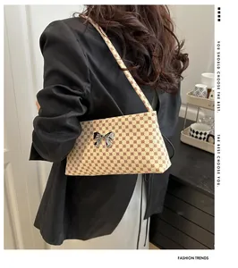 Chic butterfly shoulder bag with red polka dot pattern shown on model in black blazer