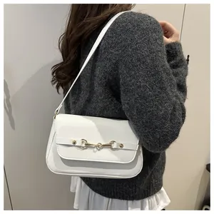Detail of white PU leather underarm bag featuring a vintage golden horsebit buckle
