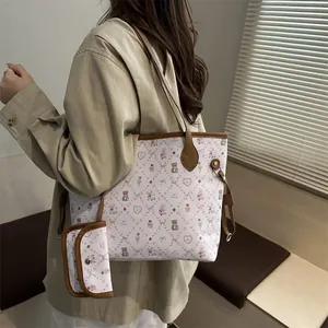 Cartoon print tote bag set with brown leather handles and matching pouch on a model