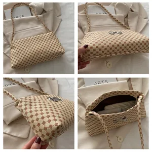 Detail view of cream shoulder bag with geometric print, silver butterfly and spacious interior