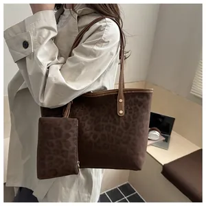 Dettaglio della borsa tote leopardata e pochette con raffinati rivetti dorati lucidi