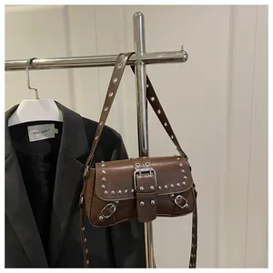 Macro view of vintage brown bag featuring silver rivets and metal eyelet details