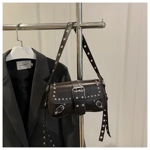 Detail of studded dark leather shoulder bag with silver eyelets and buckle accents