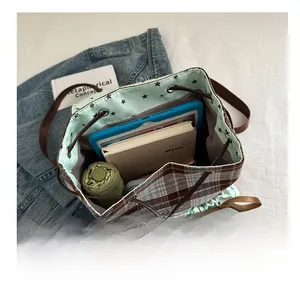 Detailed interior of a vintage plaid backpack showing storage capacity with tablet and umbrella