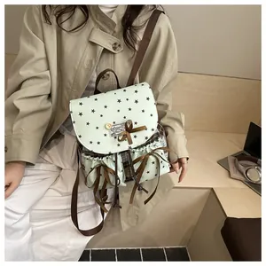 Detail of mint green lace bow backpack featuring vintage stars and plaid side design
